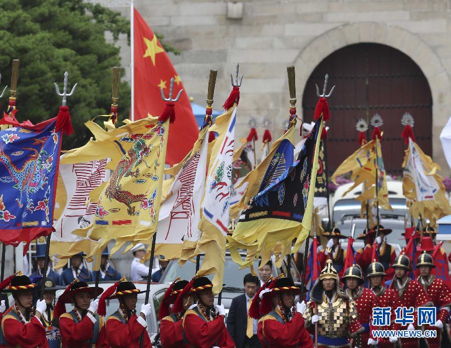 7月3日，韩国总统朴槿惠在青瓦台总统府举行隆重仪式，欢迎中国国家主席习近平对韩国进行国事访问。这是习近平的车队在身着民族服装的韩国礼仪队伍引导下驶入青瓦台。新华社记者丁林摄  